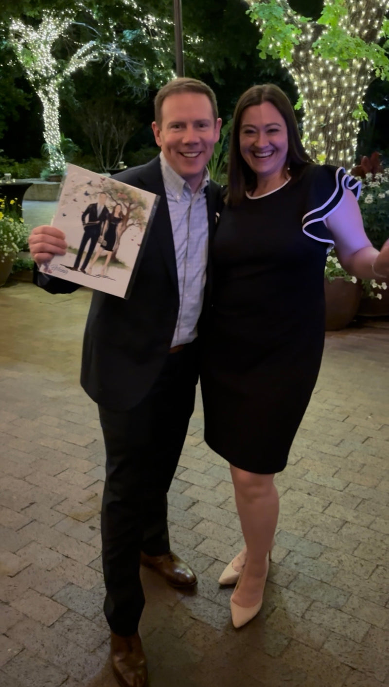 Couple with their custom guest illustration created live during a Dallas nonprofit gala at the Dallas Arboretum