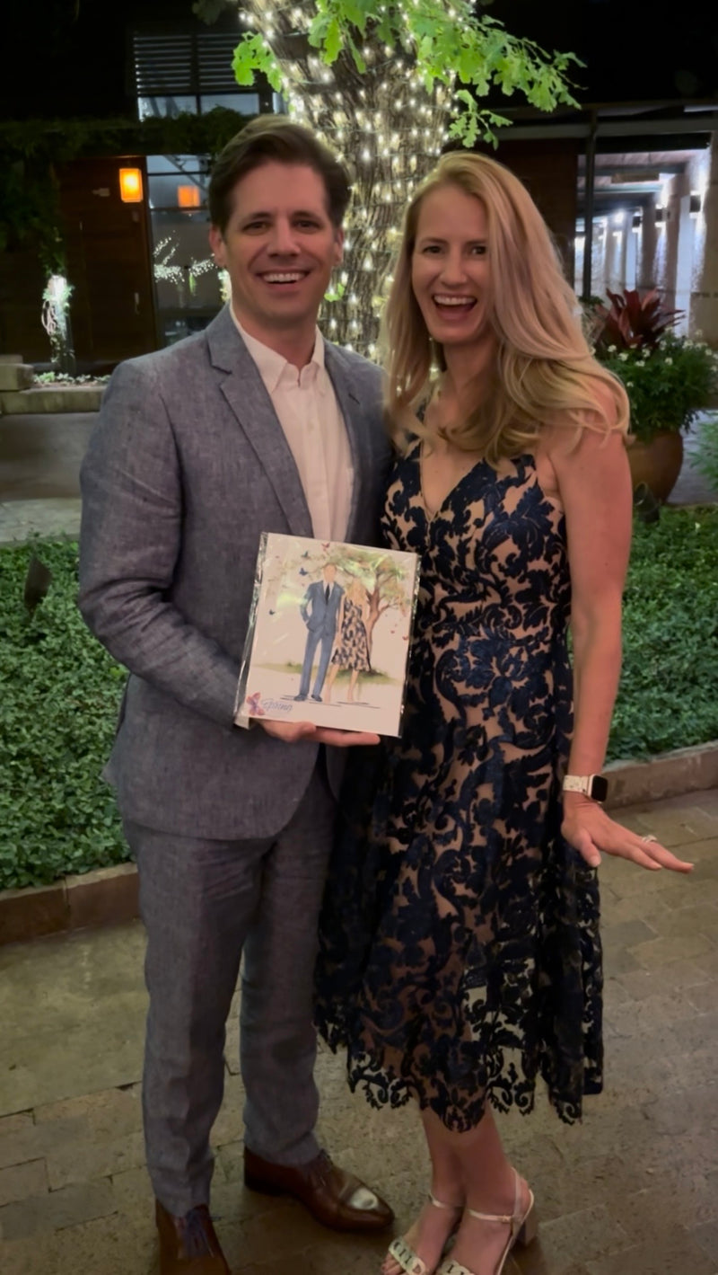 couple with their custom guest illustration created live during a Dallas nonprofit gala at the Dallas Arboretum