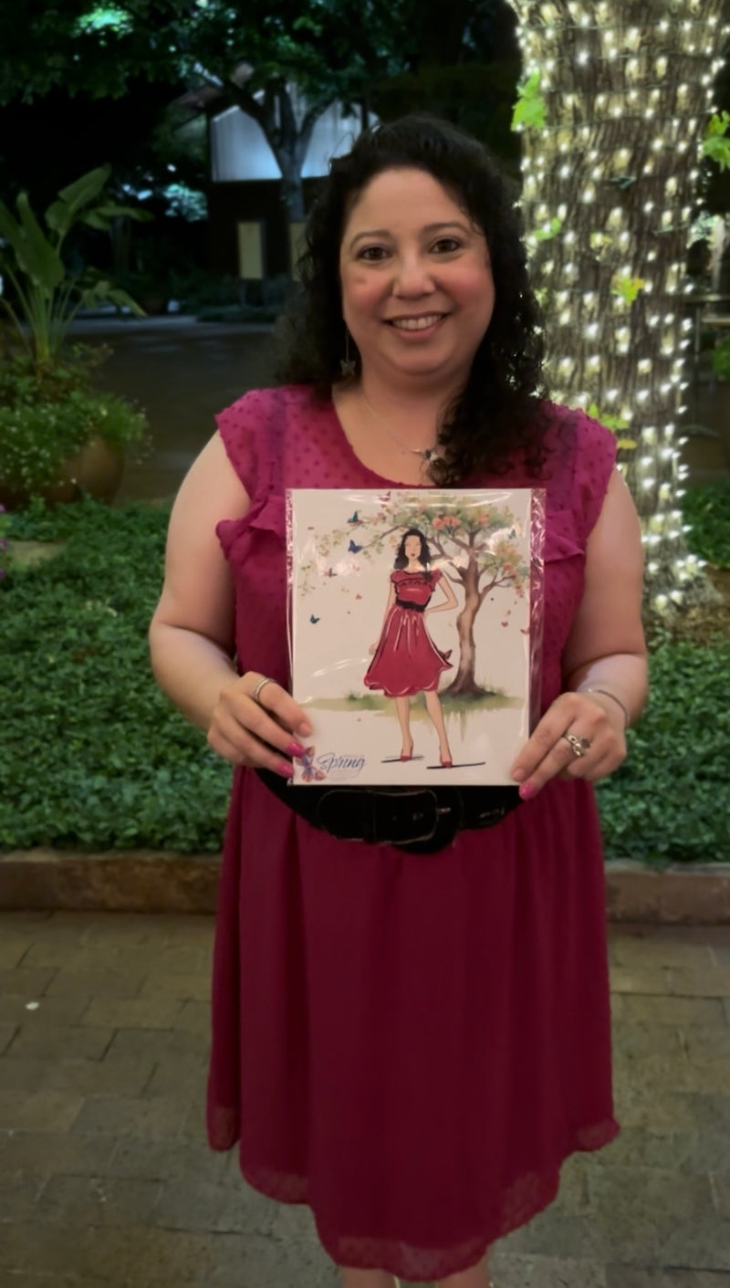 Gala guest holding her personalized live illustration at the Wings of Spring event at the Dallas Arboretum