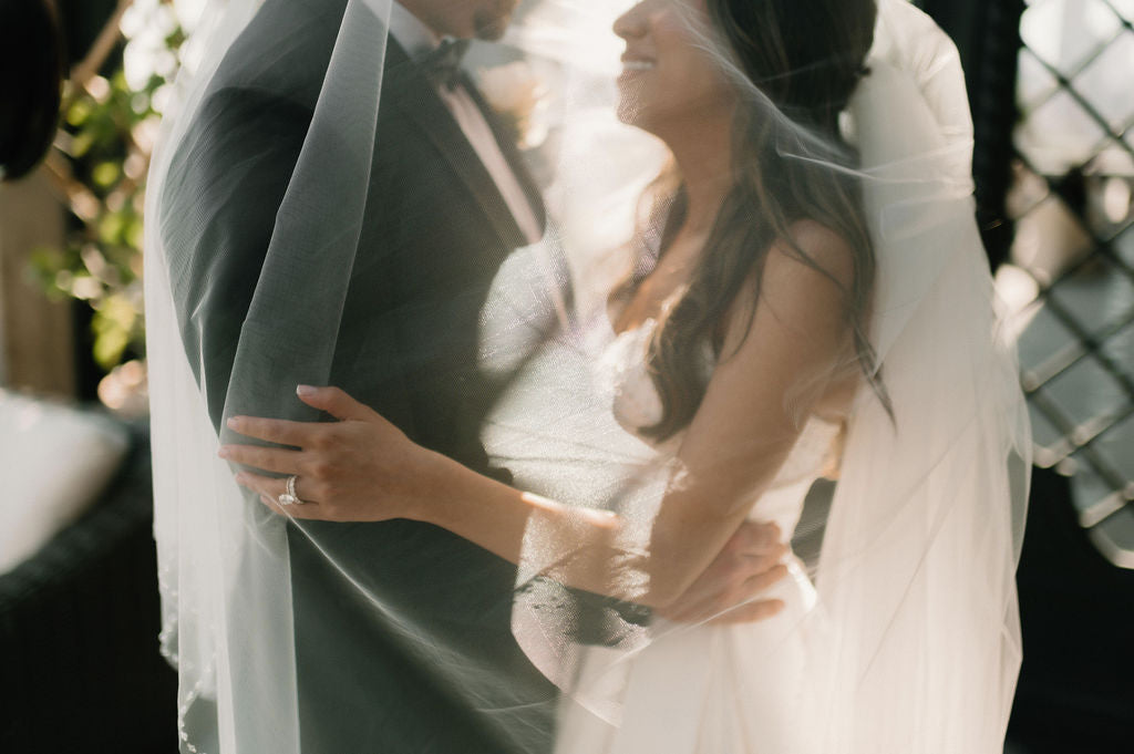 Bride and groom posing with their custom live wedding illustration at Le Tesserae in Houston.